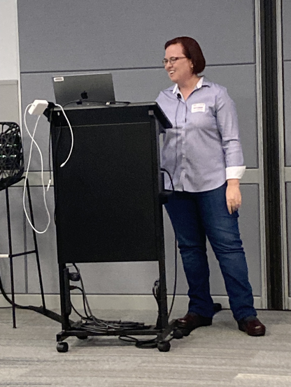 Melinda Thielbar, happy data scientist presenting at the podium at AI Security Summit