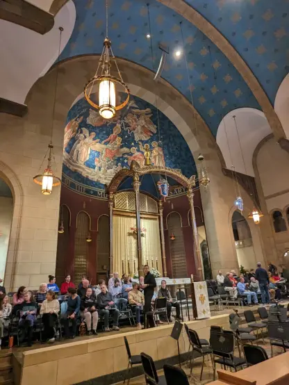Altar of Catholic Church with some choir members seated & orchestra set up