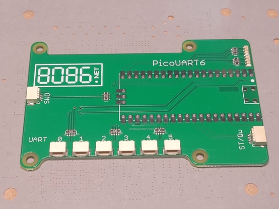Green PCB with 6 small connectors labelled UART 0 to 5 with a footprint for a Raspberry Pi Pico to be soldered either SMT or using pin headers.