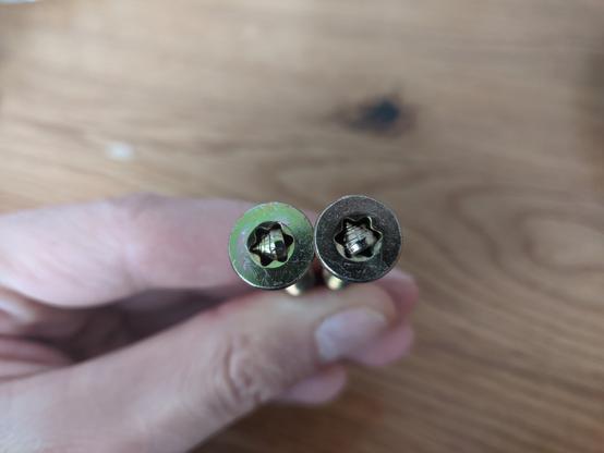 Zwei Schrauben bei denen jeweils eine abgebrochene Schraubenspitze den Torx Kopf blockiert