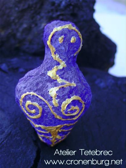 Ultramarine, spindle-shaped figure, reduced to a tiny head and a bulbous torso. Painted with golden spirals and lightning symbols.