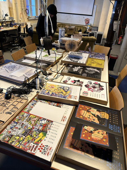 ein sehr großer Werkstatt-Tisch mit Stapeln von Kalenderblättern