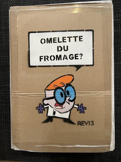 Graffiti stencil of Dexter from cartoon Dexters Laboratory saying ‘Omelette du fromage?’