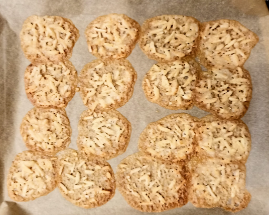 große flache karamellisierte  Plätzchen mit Mandelsplittern, die wie Spitze aussehen.