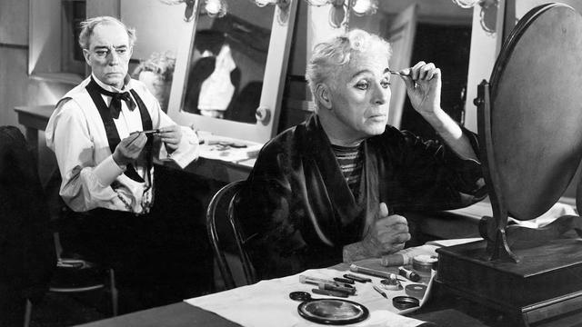 Buster Keaton watches on as Charlie Chaplin applies stage makeup in their dressing room, before going on stage to play their final musical-comedy act in the black and white film, Limelight.