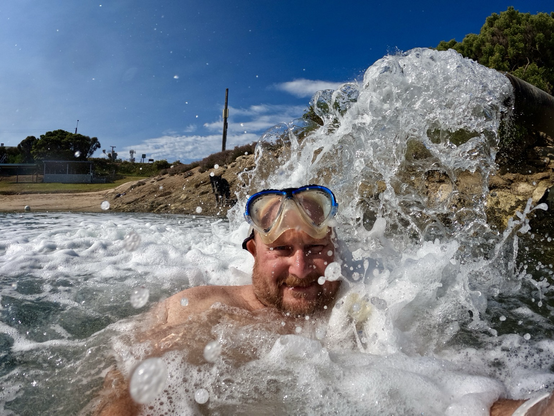 Man under a big fountain of water.
