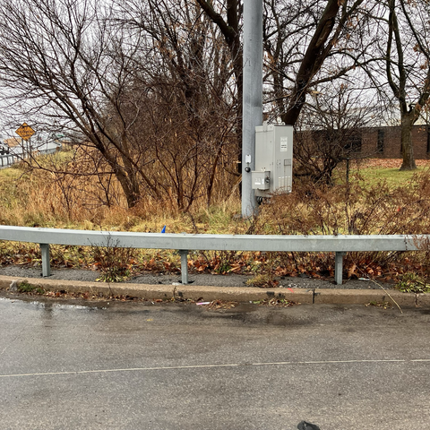 Button required to activate WALK signal to cross street is inaccessible due to guard rail and  unmown  landscape area.