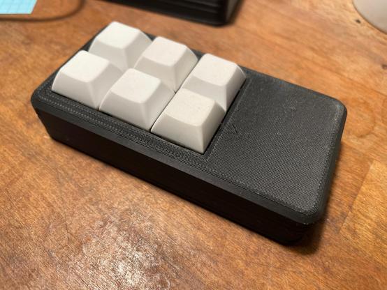A black macroprad with 6 white keys.