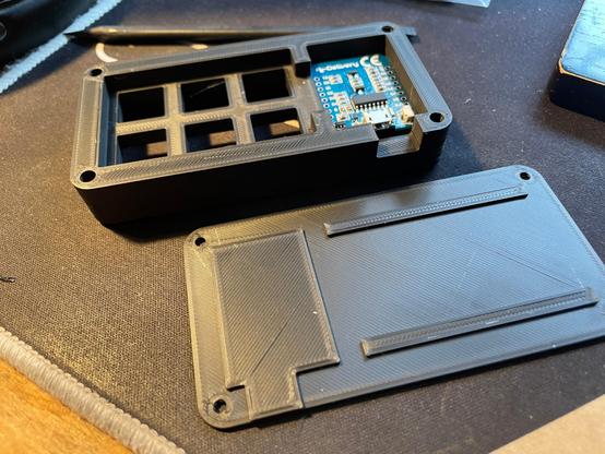 3d-printed macropad, open with a microcontroller inside.