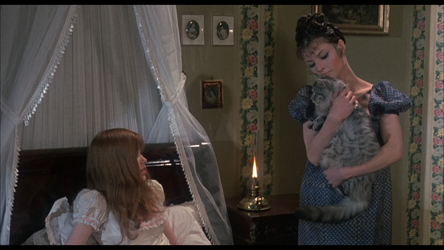 Gustaf being held by a woman, while another woman sits up in bed