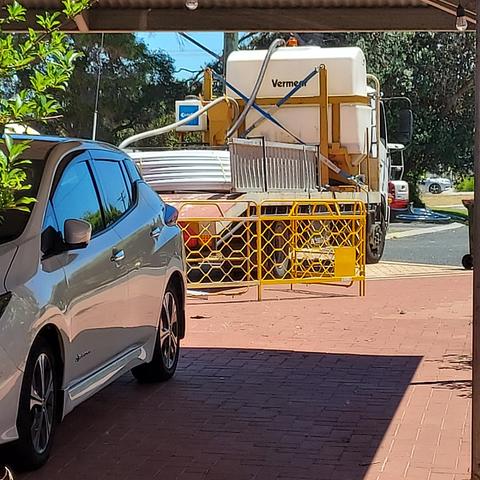 My car is in the driveway with a truck behind it, laden with NBN cables