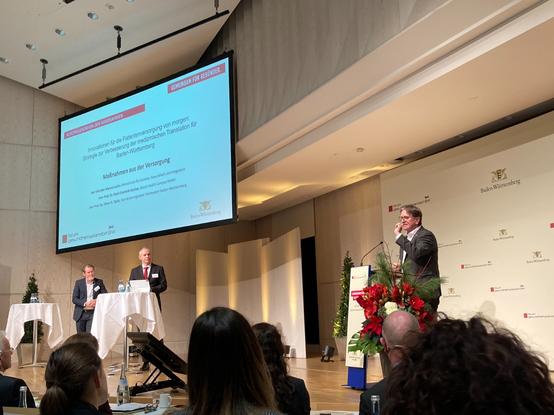 Gesundheitsminister Manne Lucha steht am Rednerpult und hält eine Eröffnungsrede zur fünften Jahresveranstaltung des Forums Gesundheitsstandort Baden-Württemberg.