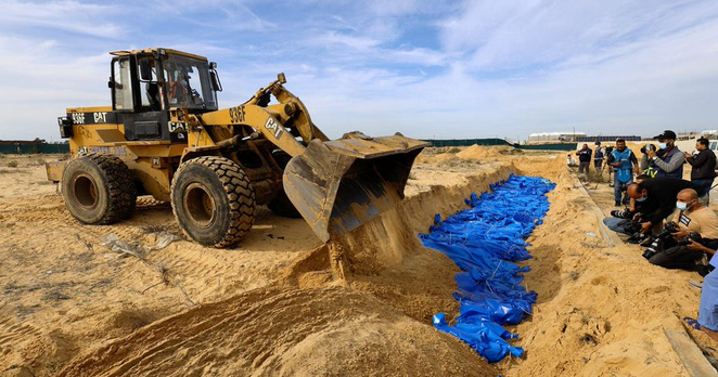 I corpi dei palestinesi uccisi negli attacchi e negli incendi israeliani sono sepolti in una fossa comune, dopo essere stati trasportati dall'ospedale Al-Shifa nella città di Gaza per la sepoltura, il 22 novembre 2023.
Credit: REUTERS/Mohammed Salem