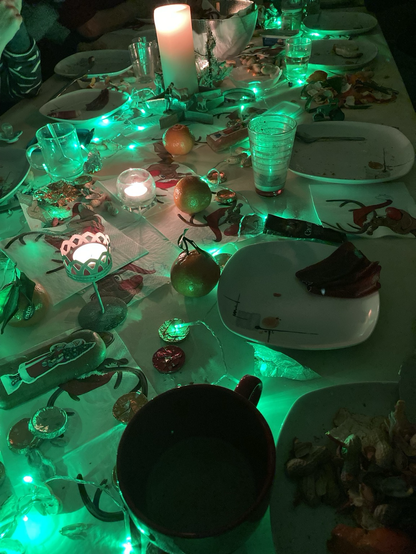 A photo of a table with food, candles and Christmas decoration for Santa Claus dinner.