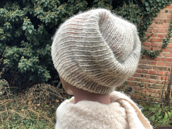 Eine Mütze, gestrickt an einer einfachen Rund Strick in den Farben, grau und beige