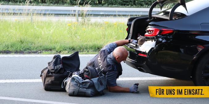 Ein Zöllner inspiziert den Unterboden eines Fahrzeugs (Symbolbild).