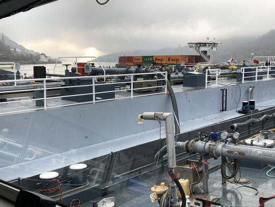 Das Leichterschiff hat längsseits am Havaristen festgemacht, Leitungen zum Umpumpen sind installiert. Im Hintergrund ist das sichernde Containerschiff zu sehen.