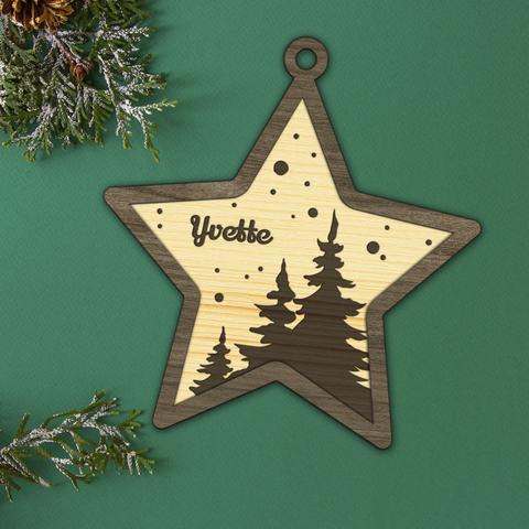 Décoration de de Noël en bois découpé et gravé en forme d'étoile dans laquelle une forêt et le prénom de votre choix sont gravés. A retrouver dans notre boutique en ligne : ernestine-etcie.fr