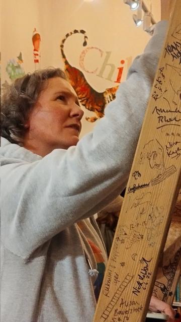 author Kirsty Maynor signing the Edinburgh Bookshop bookcase ladder