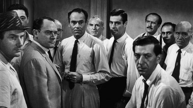 A still from the movie 12 Angry Men showing a black and white image of the jury