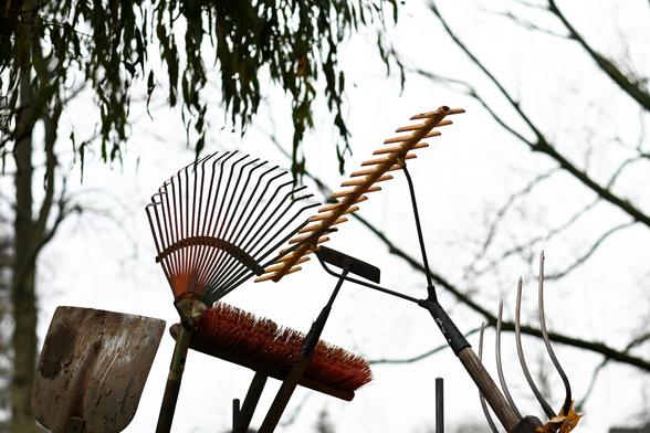 Ein Rechen, eine Harke, ein Besen, eine Mistforke, eine Schaufel und so'n Dings zum Unkrautjäten ragen in den herbstgrauen Himmel des Kurparks in Hennef.