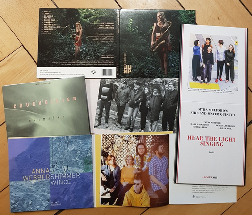 assembly of CDs on wooden floor - clockwise:
Julieta Eugenio, "Jump"
Myra Melford's Fire and Water Quintet, "Hear the Light Singing"
Anna Webber, "Shimmer Wince"
Sylvie Courvoisier, "Chimaera"
