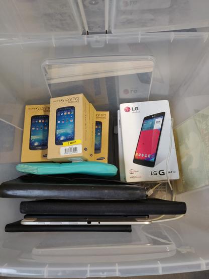 caisse pleine de vieux smartphones et quelques tablettes