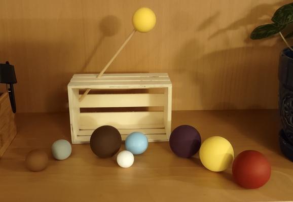 A nativity scene with the wise men, Mary, Joseph, Jesus, and donkey and sheep represented by painted wood balls of various colours and sizes.