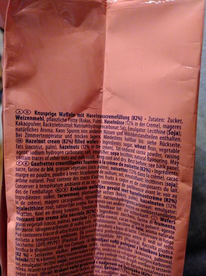(A) (D) Knusprige Waffeln mit Haselnusscremefüllung (82%). Zutaten: Zucker, Weizenmehl, pflanzliche Fette (Kokos, Palm), Haselnüsse (12% in der Creme), mageres Kakaopulver, Backtriebmittel: Natriumhydrogencarbonat; Salz, Emulgator: Lecithine (Soja); natürliches Aroma. Kann Spuren von anderen Nüssen und Milchbestandteilen enthalten. Bei Zimmertemperatur und trocken lagern.