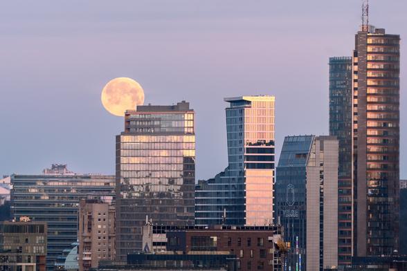 Cityscape during sunrise with the full moon
