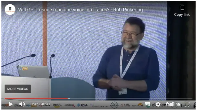 Screenshot of the Youtube video of Rob Pickering on stage at CommCon 2023, giving his talk about conversational AI