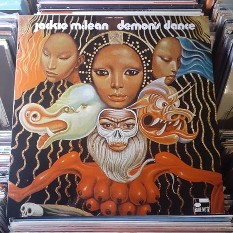 Album cover features a painting that shows a configuration of three women's faces at the top, with two masks (a pachyderm and a demon) below those,  and a sort of skeleton mask with a beard at the bottom, just above an orange torso with nine breasts. It's pretty freaky.