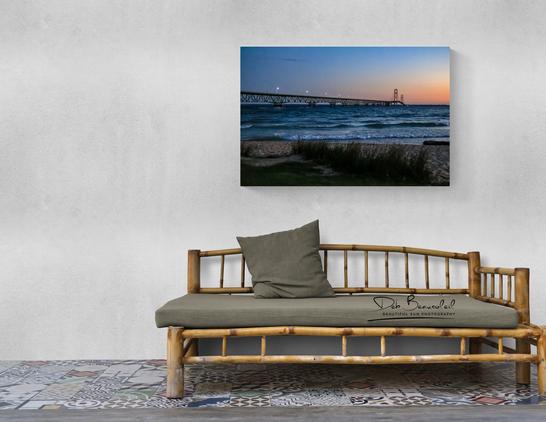 Room mock up with brown couch - featured image on the wall by Deb Beausoleil (Mackinac Sunrise). Mackinac Bridge at Sunrise. Low light, pink sky on the horizon and blue sky above. Blue water with small waves. Some lights on the Mackinac Bridge. Brown sand and beach grass in the foreground.  Image at:  https://beautifulsunphotography.com/featured/mackinac-sunrise-deb-beausoleil.html  See more art & blog at: https://beautifulsunphotography.com/ https://debbeautifulsunphotography.com/  https://debbeausoleil.com