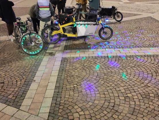 Einige Fahrräder und Lastenräder mit bunten Lichtern