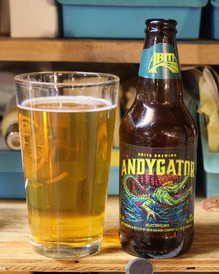 A dark brown beer bottle labelled “Abita Andygator,” next to a pint glass almost filled with a gold colored liquid topped with a ring of foam.