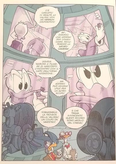 Two antropomorphic ducks in a lab with some complex machines are looking at a screen. The wall behind them on the other side of the big room is completely covered in 4 huge screens, in each of which it is shown a part of a story involving Double Duck.