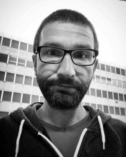 Selfie showing me in front of the office building where I was working in 2019. The photo has the iPhone’s mono filter applied.
