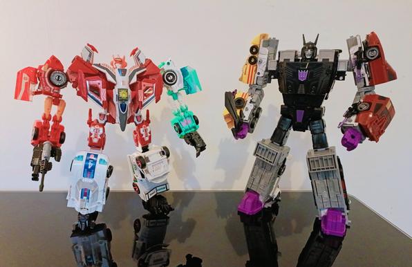 Elita Infinite (left) stood next to Menasor (right). The Combiner Wars combiner design Elita uses tends to look a little simian in terms of proportion. Arms a fraction too long and legs too short. By contrast Menasor using a more recent design taking full advantage of Motormaster's huge  trailer has a more human set of proportions in combined mode.

Fun detail: Elita Infinite has the "Autobot Enigma" in her chest, a toyetic version of the Enigma of Combination, a powerful artefect that grants combination ability to any Transformer!