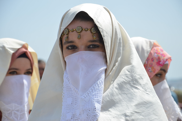 The white face cover in close-up in an unrelated photo. The top is solid linen/cotton/etc, the lower part is lace. The headscarf is broken white.