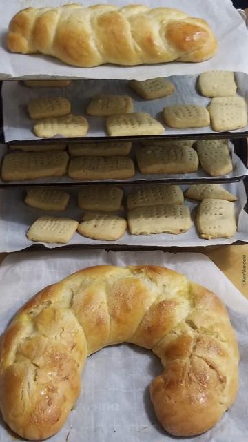 3 trays of shortbread & 2 braided loaves of bulle stacked vertically to cool.