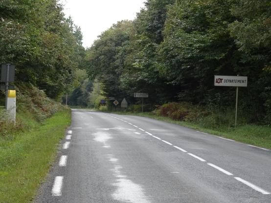 Borne routière de délimitation des Départements de la Dordogne et du Lot à gauche, panneau de signalisation d'entrée dans le Département du Lot à droite