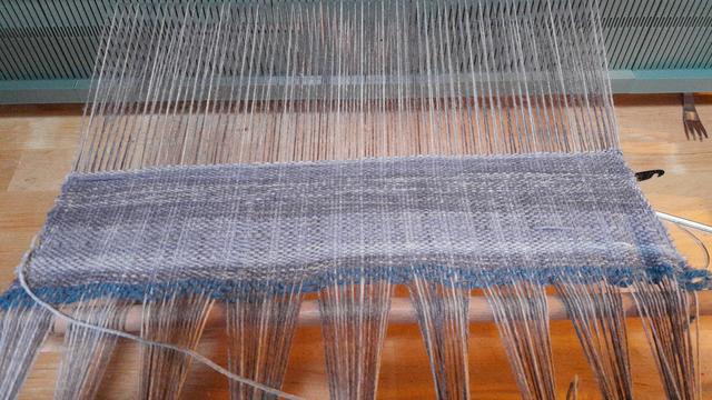 les dix premiers centimètres d'écharpe laissent voir une longue variation de teines de gris: une petite section suivie parprès de la moitié dans une teinte médiane,  puis une teinte plus foncée. les variations de la chaîne laissent apparaître un discret quadriage aléatoire dans les mêmes tons. les bords se resserrent un peu trop vers le centre.