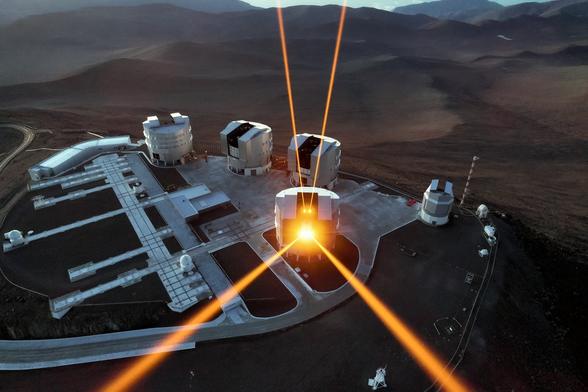 Twinkling stars are far more desirable to poets and romantics than to astronomers. Even in the near-pristine seeing conditions over Chile, home to ESO’s fleet of world-class telescopes, turbulence in Earth’s atmosphere causes stars to twinkle, blurring our view of the night sky.

These four laser beams are specially designed to combat this turbulence. The intense orange beams dominating this image originate from the 4 Laser Guide Star Facility, a state-of-the-art component of the Adaptive Optics Facility of ESO’s Very Large Telescope (VLT). Each beam is some 4000 times more powerful than a standard laser pointer! Each creates an artificial guide star by exciting sodium atoms high in the Earth’s upper atmosphere and causing them to glow.

Creating artificial guide stars allows astronomers to measure and correct for atmospheric distortion, by adjusting and calibrating the settings of their observing equipment to be as accurate as possible for that particular area of sky. This gives the VLT a crystal-clear view of the cosmos, so it can capture the wonders of the Universe in stunning detail.

This amazing capture was taken using a drone flown over the VLT by ESO Photo AmbassadorGerhard Hüdepohl.