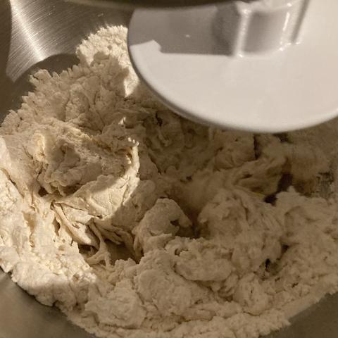 In einer Edelstahlschüssel wird Brotteig geknetet