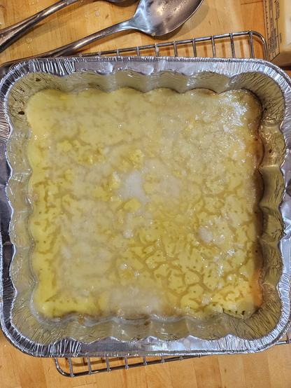 Pan of lemon bars with cracks drom not baking properly,  slathered in gooey sigar glaze