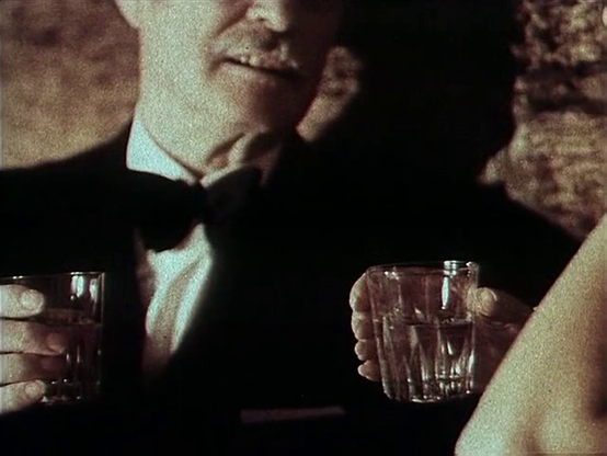 Monique (Silke Humel, R) spending Christmas Eve in a bar, looking for a way out. She's speaking to an elderly man in an expensive tuxedo. Is this it?