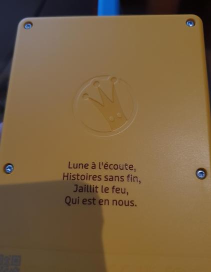 Verso du Glam de Lunii, gravé du poème : 
« Lune à l'écoute,
Histoires sans fin,
Jaillit le feu,
Qui est en nous. »