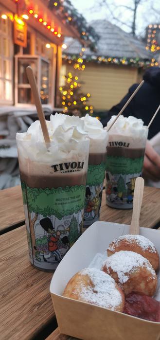 Trois chocolats chauds chantilly avec une barquette de boulettes de crêpes au sucre glace et à la confiture
