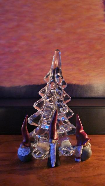 Crystal Christmas tree surrounded bt gnomes. Warm candle light.
