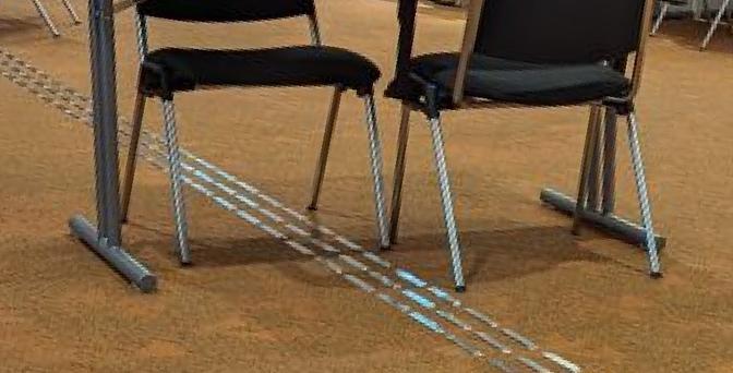 Cropped image of table legs and chairs standing right in the middle of a tactile path.
